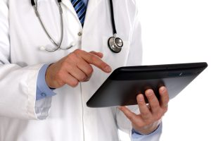 An image of a male doctor viewing an electronic tablet.