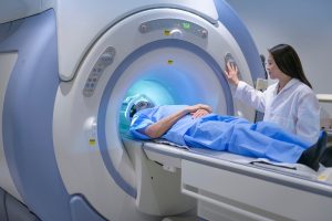 A technologist operates the MRI while a patient is laying inside the machine.