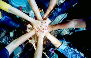 A photo of a group of healthcare workers placing hands together as a team.