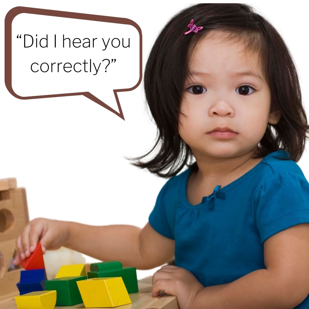A toddler playing with blocks as she asks, "Did I hear you correctly?"